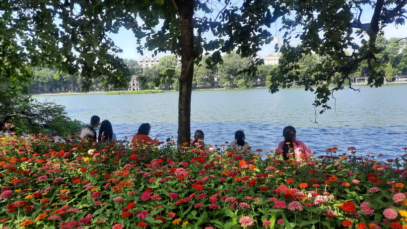 A group of people sitting by a lake

Description automatically generated