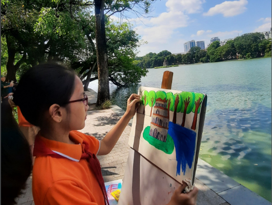 A person painting a picture outside

Description automatically generated
