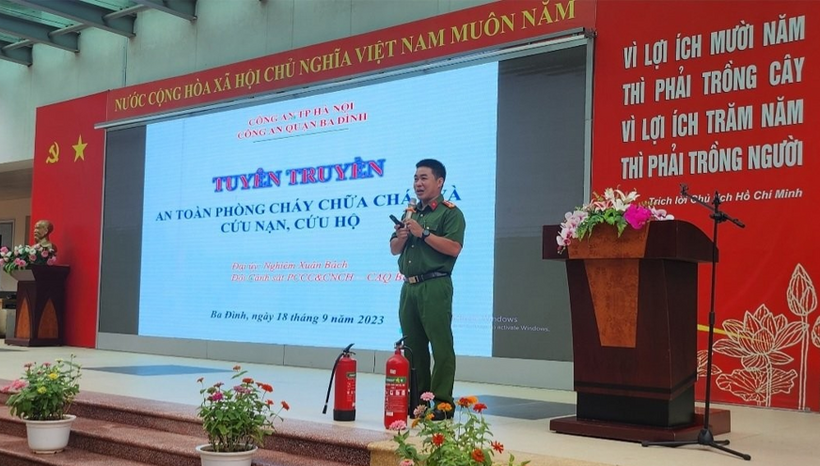 A person in uniform standing in front of a large screen

Description automatically generated