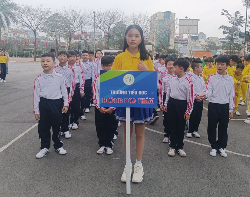 A group of children standing in a line holding a sign

Description automatically generated