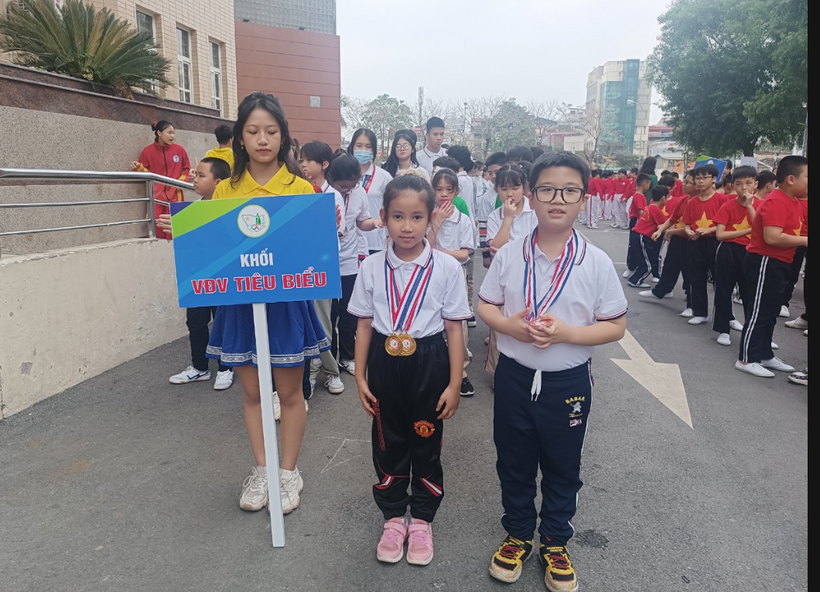 A group of children standing in a street holding a sign

Description automatically generated