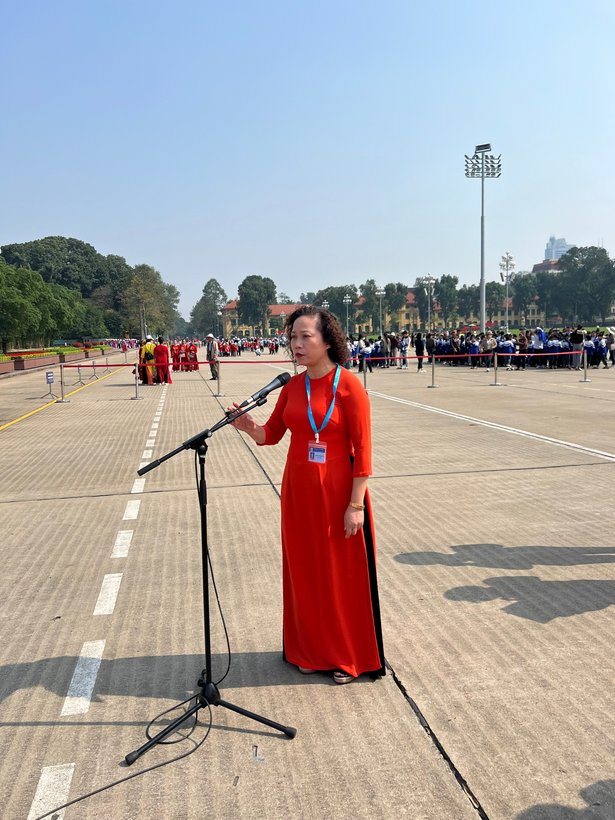 A person in a red dress standing in front of a microphone

Description automatically generated