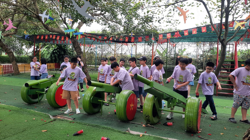 A group of people standing on a green machine

Description automatically generated